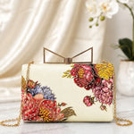 Crimson Flora Printed Highlight Clutch with bold crimson floral artwork on an ivory base, gold frame clasp, detachable chain, and luxurious handcrafted-inspired finish.
