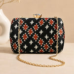 Ebony Ikat Clutch featuring black Ikat-inspired woven pattern, gold chain strap, and crystal clasp