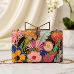 Floral Fiesta Printed Highlight Clutch featuring vibrant multicolour floral prints with intricate detailing, gold frame clasp, detachable chain, and elegant party-ready design.