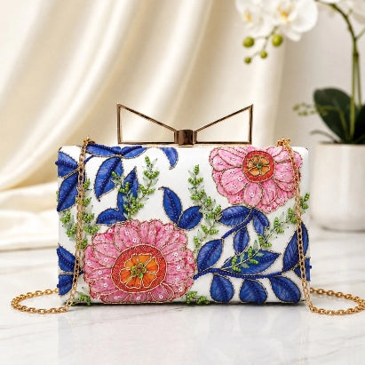 Floral Symphony Printed Highlight Clutch featuring blue foliage, pink floral artwork, printed highlights, and a gold chain strap.