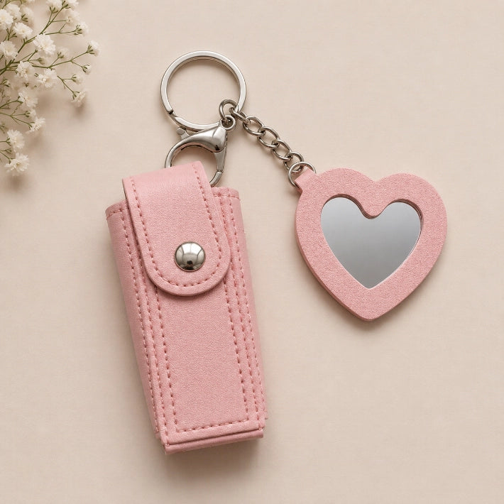 Pink faux leather lipstick keychain holder with a heart-shaped mirror, ideal as a travel makeup accessory, handbag organizer, and gift hamper essential.