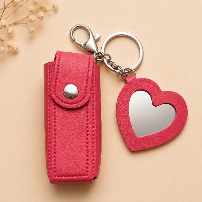 Red faux leather lipstick keychain holder with a heart-shaped mirror, ideal as a travel makeup accessory, handbag organizer, and gift hamper essential.