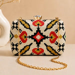 Ivory Heritage Clutch with elegant ivory woven heritage pattern, gold chain strap, and crystal clasp