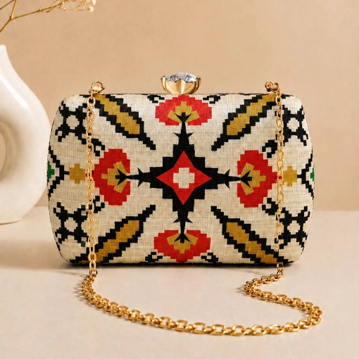 Ivory Heritage Clutch with elegant ivory woven heritage pattern, gold chain strap, and crystal clasp