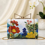 Meadow Bloom Printed Highlight Clutch with colourful meadow-inspired floral artwork, gold-tone frame clasp, detachable chain, and premium designer finish.