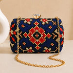 Midnight Ikat Clutch featuring navy blue Ikat-inspired woven pattern, gold chain strap, and crystal clasp