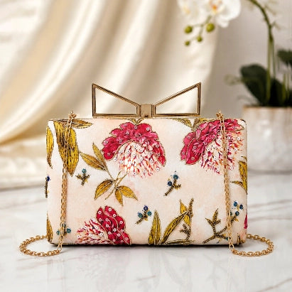 Pink Blossom Meadow Printed Highlight Clutch with delicate pink floral artwork on an ivory base, gold frame clasp, detachable chain, and premium designer finish.