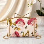 Pink Blossom Meadow Printed Highlight Clutch with delicate pink floral artwork on an ivory base, gold frame clasp, detachable chain, and premium designer finish.