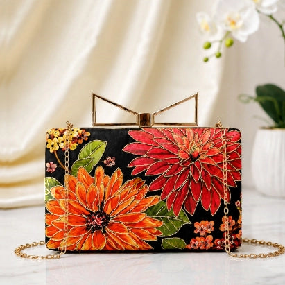 Scarlet Bloom Printed Highlight Clutch featuring vibrant red and orange floral artwork with printed highlights and a gold chain strap.