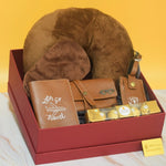 The Wanderlust Luxe Hamper featuring a premium travel neck pillow, eye mask, passport cover, leather spectacle case, luggage tag, Ferrero Rocher chocolates, and luxury gift box by YelloWraps.