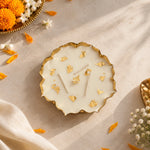 Elegant golden wax urli with white wax and gold flakes, styled with marigold flowers and festive décor.