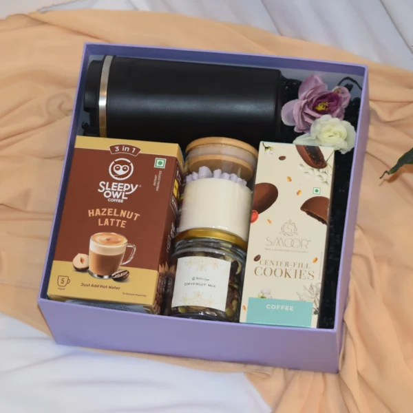 The Corporate Cozy Delight is ahamper with all premium gourmet goodies and a vaccum travel mug