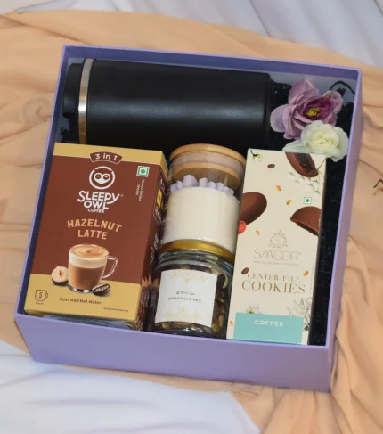 The Corporate Cozy Delight is ahamper with all premium gourmet goodies and a vaccum travel mug